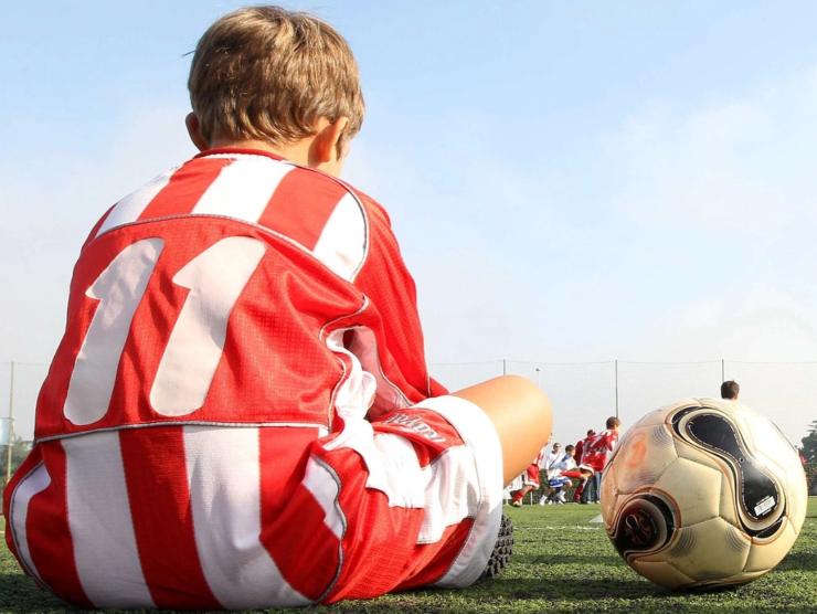 calcio giovanile: giovanissimo calciatore affranto fuori dal terreno di gioco (fonte web)