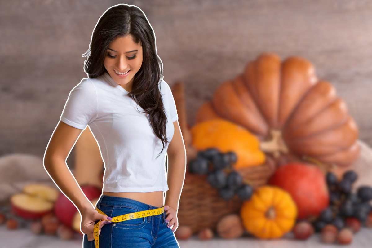 ragazza che si misura la vita e alimenti sullo sfondo